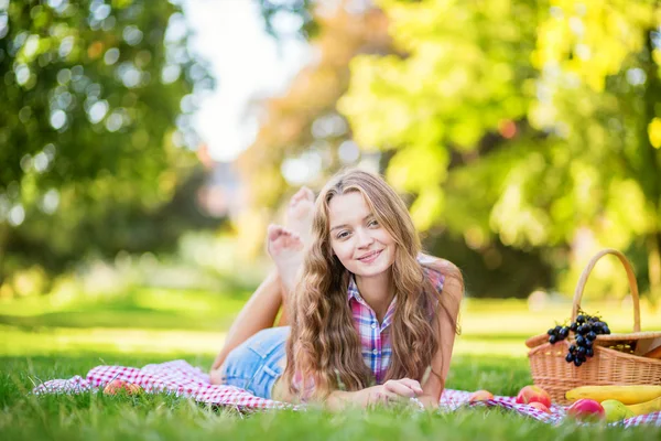 Menina bonita fazendo um piquenique no parque . — Fotografia de Stock