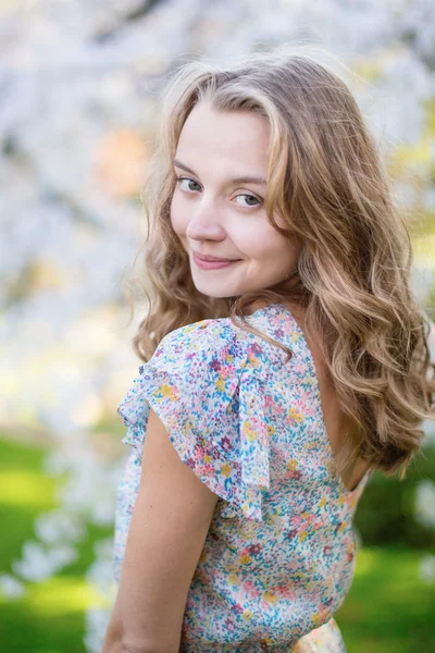 Hermosa mujer en floreciente jardín de cerezos — Foto de Stock