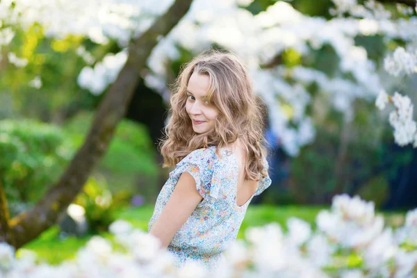 Schöne Frau im blühenden Kirschgarten — Stockfoto