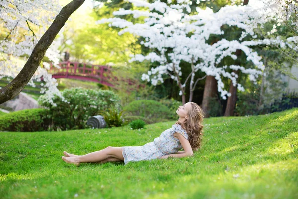 Young woman relaxing in cherry garden — Stock Photo, Image