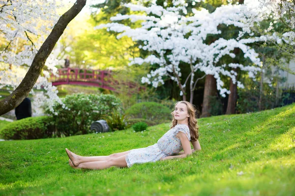 Młoda kobieta relaksu w ogrodzie wiśnia — Zdjęcie stockowe