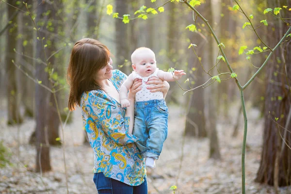 Ung mamma med sin son i en skog med våren — Stockfoto