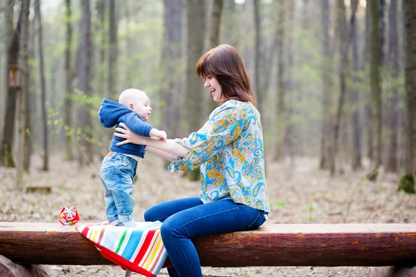 Jovem mãe com seu bebê em uma floresta — Fotografia de Stock