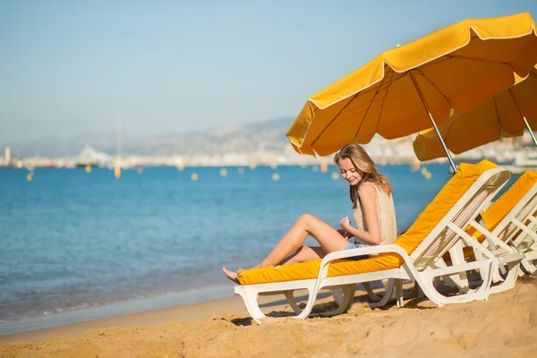 Menina bonita relaxante em uma cadeira de praia — Fotografia de Stock