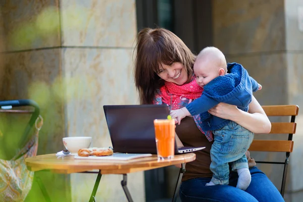 Young working mother with little son in a cafe — Stock Photo, Image