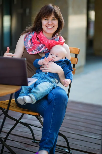 Junge berufstätige Mutter mit kleinem Sohn im Café — Stockfoto