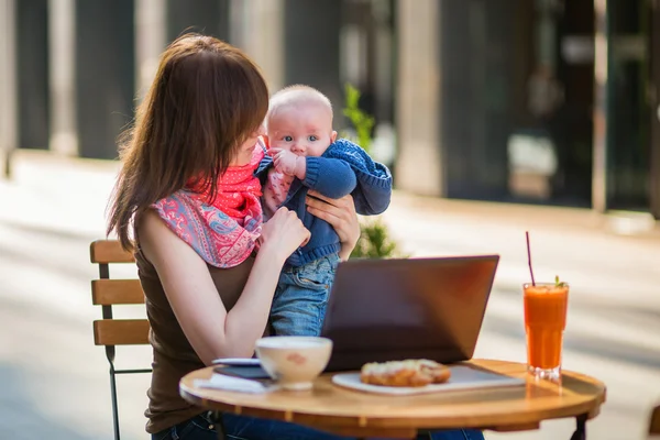 Young working mother with little son in a cafe — Stock Photo, Image