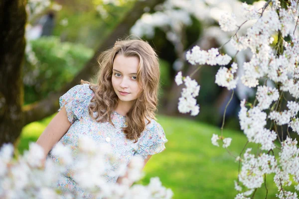 Mujer joven en floreciente jardín de cerezos —  Fotos de Stock