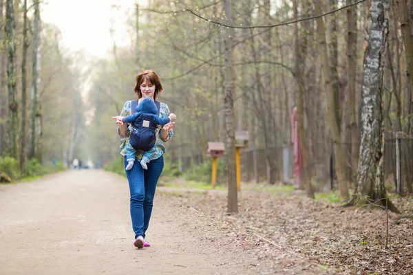 Молодая мать гуляет в лесу со своим ребенком — стоковое фото