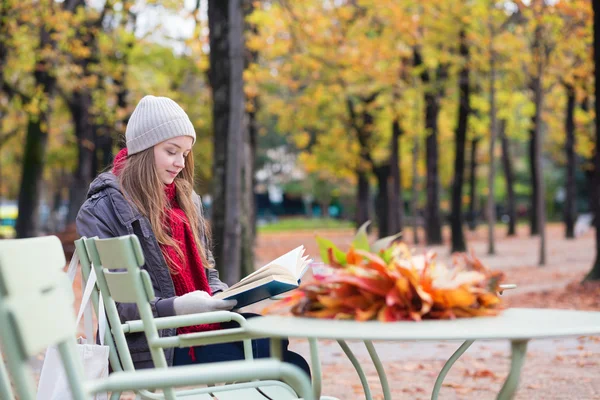 Menina lendo um livro em um café ao ar livre — Fotografia de Stock