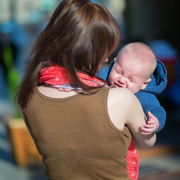 Pequeño niño llorando en brazos de madre — Foto de Stock