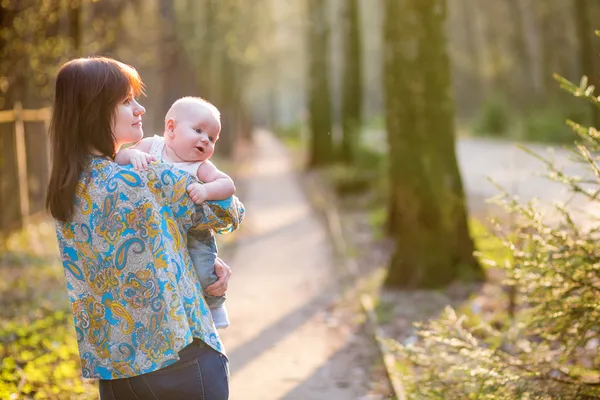 Jovem mãe com seu bebê na floresta — Fotografia de Stock