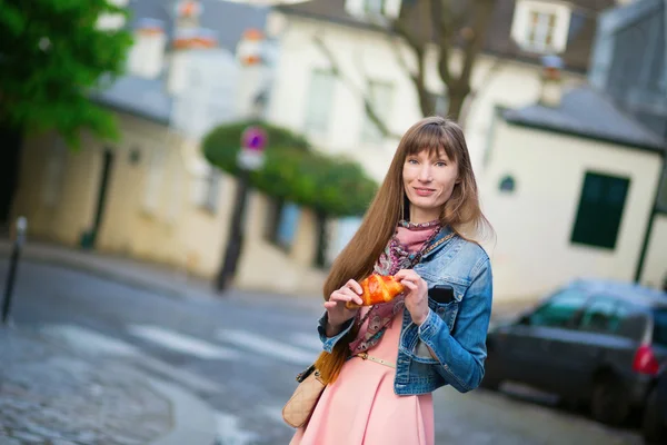 Parisli bir sokakta kruvasan ile kız — Stok fotoğraf