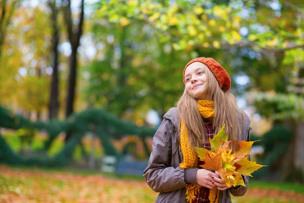 Young girl with bunch of leaves on a fall day — Stock Photo, Image