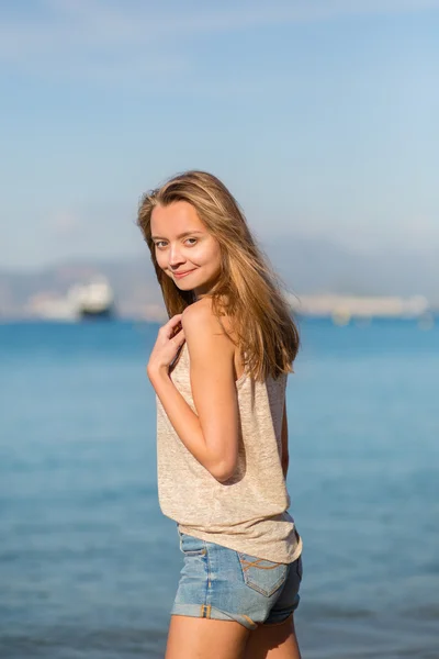 Ung kvinna poserar nära havet — Stockfoto