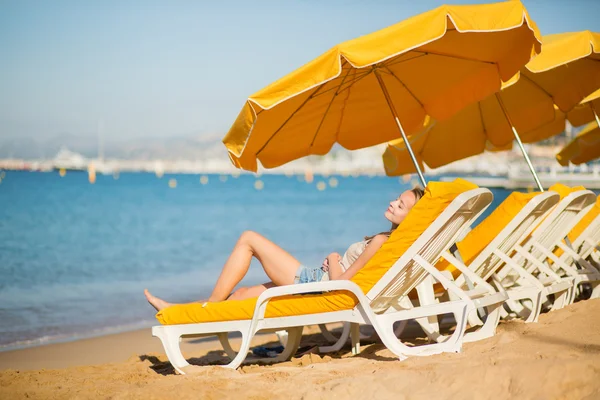 Dziewczyna na krześle plaży, w pobliżu morza — Zdjęcie stockowe