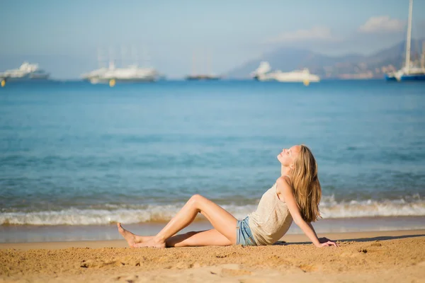 Mujer joven relajándose en la playa — Foto de Stock