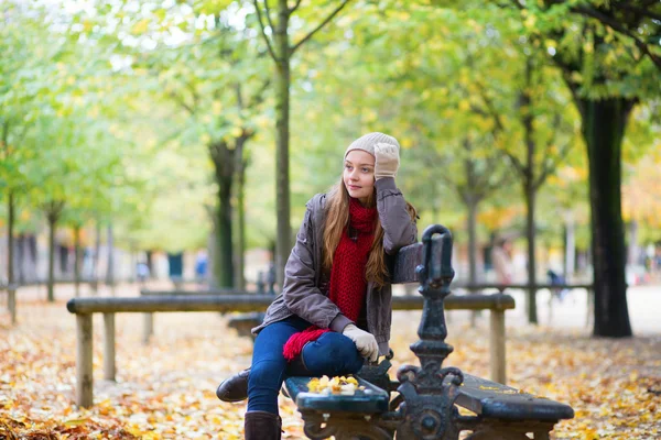 Meisje zitten op bank in park — Stockfoto