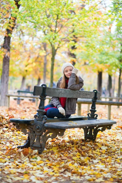 Szomorú lány ül egy padon a parkban — Stock Fotó