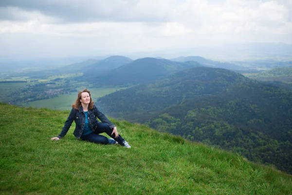 Menina sentada na encosta do vulcão em Auvergne — Fotografia de Stock