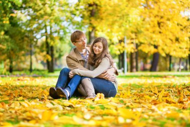 Dating couple in yellow leaves on a fall day