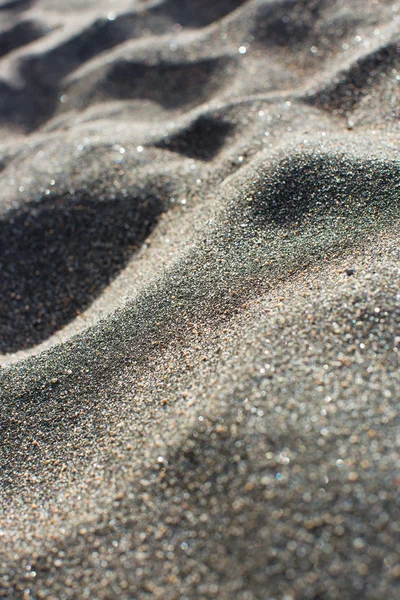 Close-up van zwart vulkanisch zand op een strand — Stockfoto