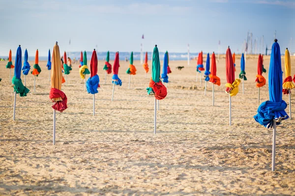 Známé barevné slunečníky na pláži deauville — Stock fotografie