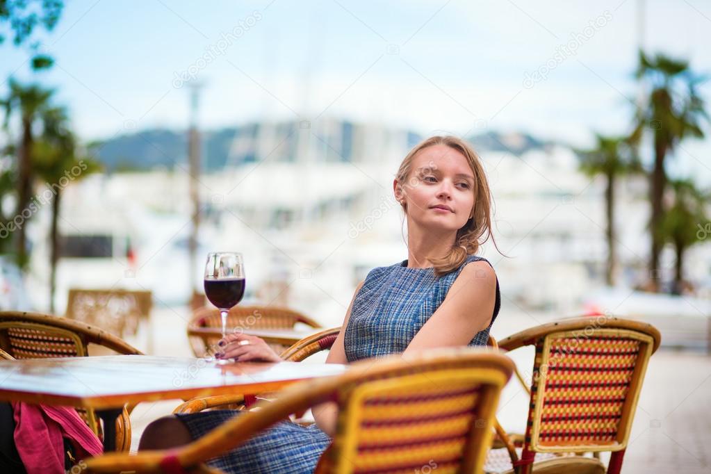 Young French woman drinking red wine