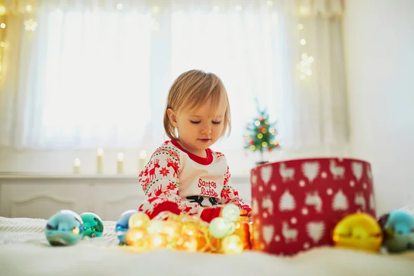 Glad Liten Småbarnsflicka Pyjamas Och Leker Med Julpynt Sängen Fira — Stockfoto