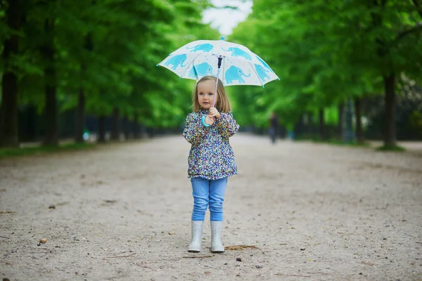 비오는 우산을 신은아이 스러운 아장아장 소녀는 비오는 재미를 아이들을 야외에서의 — 스톡 사진