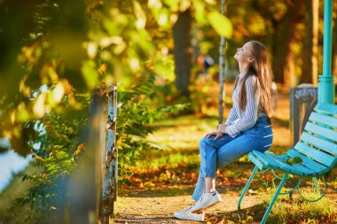 Güzel genç bayan Paris, Fransa 'da güneşli bir sonbahar gününün tadını çıkarıyor. Sonbahar sezonunda Fransa 'da turist tatili