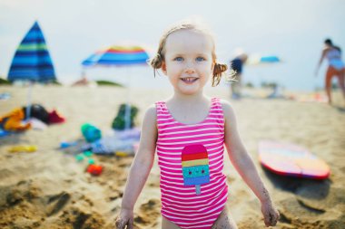 Mutlu küçük kız Fransa 'nın Akdeniz sahillerinde eğleniyor. Neşeli çocuk denizde tatilin tadını çıkarıyor. Çocuklar için açık hava yaz etkinlikleri