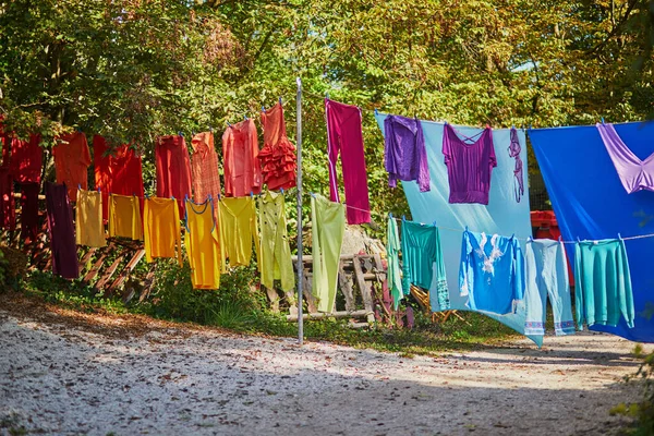 カラフルな服は ロープの虹の色を繰り返すにかかっている 洗濯は屋外で乾燥している — ストック写真