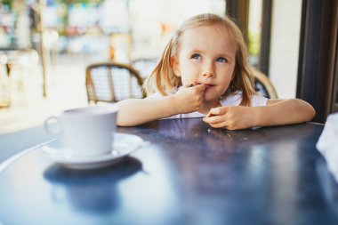 Paris kafesinde ya da restoranında üç yaşında sevimli bir kız. Çocuk konseptiyle çıkmak