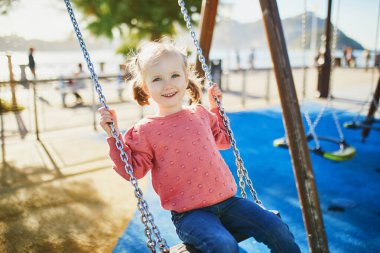 Salıncakta sallanan 4 yaşındaki kızın kutlu olsun. Oyun bahçesinde tahterevallide sallanan mutlu çocuk. Çocuklar için açık hava yaz etkinlikleri