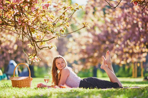 Mooie Jonge Vrouw Picknicken Zonnige Lentedag Park Tijdens Kersenbloesem Seizoen — Stockfoto