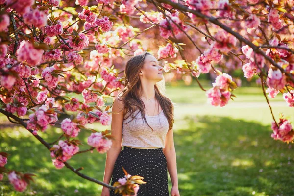 桜の季節に公園で晴れた春の日に美しい若い女性 フランス パリ近郊の有名なスコー公園の若い女性 — ストック写真