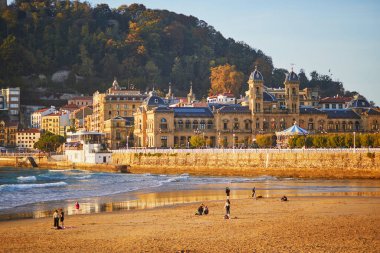 SAN SEBASTIAN, İspanya - 26 Ekim 2021: San Sebastian, İspanya 'daki plajda yürüyen insanlar