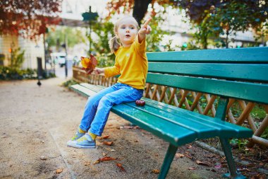 Paris, Fransa 'da bir sokakta bankta oturan üç yaşındaki sevimli bir kız.