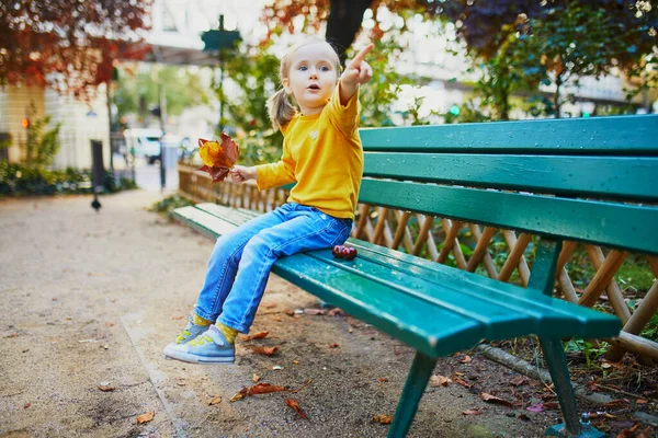 Entzückendes Dreijähriges Mädchen Sitzt Auf Einer Bank Auf Einer Straße — Stockfoto