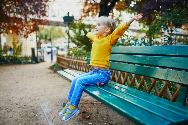 Paris, Fransa 'da bir sokakta bankta oturan üç yaşındaki sevimli bir kız.
