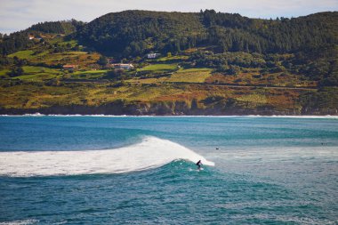 Surfer catching wave in Mundaka, Basque Country, Spain