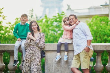 Dört kişilik mutlu bir aile Paris, Fransa seyahatinin tadını çıkarıyor. Anne, baba, oğul ve kız Paris 'teki Eyfel Kulesi yakınlarında. Evli ve çocuklu çift Fransa 'ya seyahat ediyor.