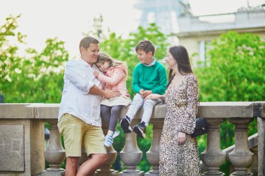 Dört kişilik mutlu bir aile Paris, Fransa seyahatinin tadını çıkarıyor. Anne, baba, oğul ve kız Paris 'teki Eyfel Kulesi yakınlarında. Evli ve çocuklu çift Fransa 'ya seyahat ediyor.
