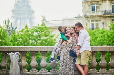 Dört kişilik mutlu bir aile Paris, Fransa seyahatinin tadını çıkarıyor. Anne, baba, oğul ve kız Paris 'teki Eyfel Kulesi yakınlarında. Evli ve çocuklu çift Fransa 'ya seyahat ediyor.