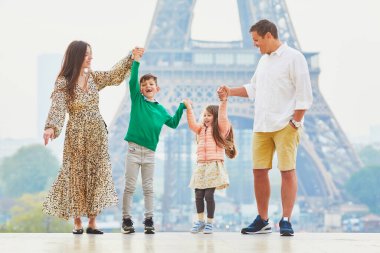 Dört kişilik mutlu bir aile Paris, Fransa seyahatinin tadını çıkarıyor. Anne, baba, oğul ve kız Paris 'teki Eyfel Kulesi yakınlarında. Evli ve çocuklu çift Fransa 'ya seyahat ediyor.