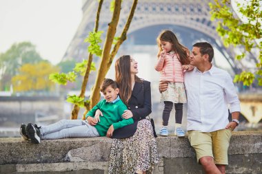 Dört kişilik mutlu bir aile Paris, Fransa seyahatinin tadını çıkarıyor. Anne, baba, oğul ve kız Paris 'teki Eyfel Kulesi yakınlarında. Evli ve çocuklu çift Fransa 'ya seyahat ediyor.