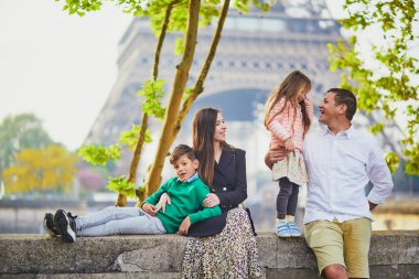 Dört kişilik mutlu bir aile Paris, Fransa seyahatinin tadını çıkarıyor. Anne, baba, oğul ve kız Paris 'teki Eyfel Kulesi yakınlarında. Evli ve çocuklu çift Fransa 'ya seyahat ediyor.