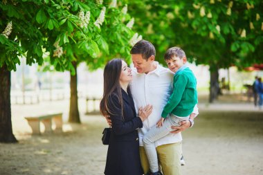 Üç kişilik mutlu bir aile Paris, Fransa yolculuğunun tadını çıkarıyor. Anne, baba ve oğul Paris 'teki Tuileries bahçesinde. Evli ve çocuklu çift Fransa 'ya seyahat ediyor.
