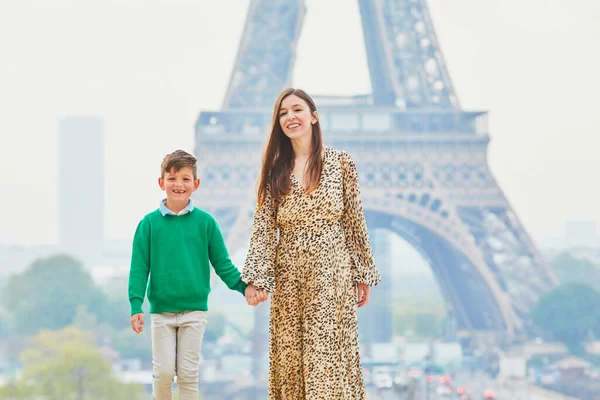 Happy family of two enjoying their trip to Paris, France. Mother and son near the Eiffel tower in Paris